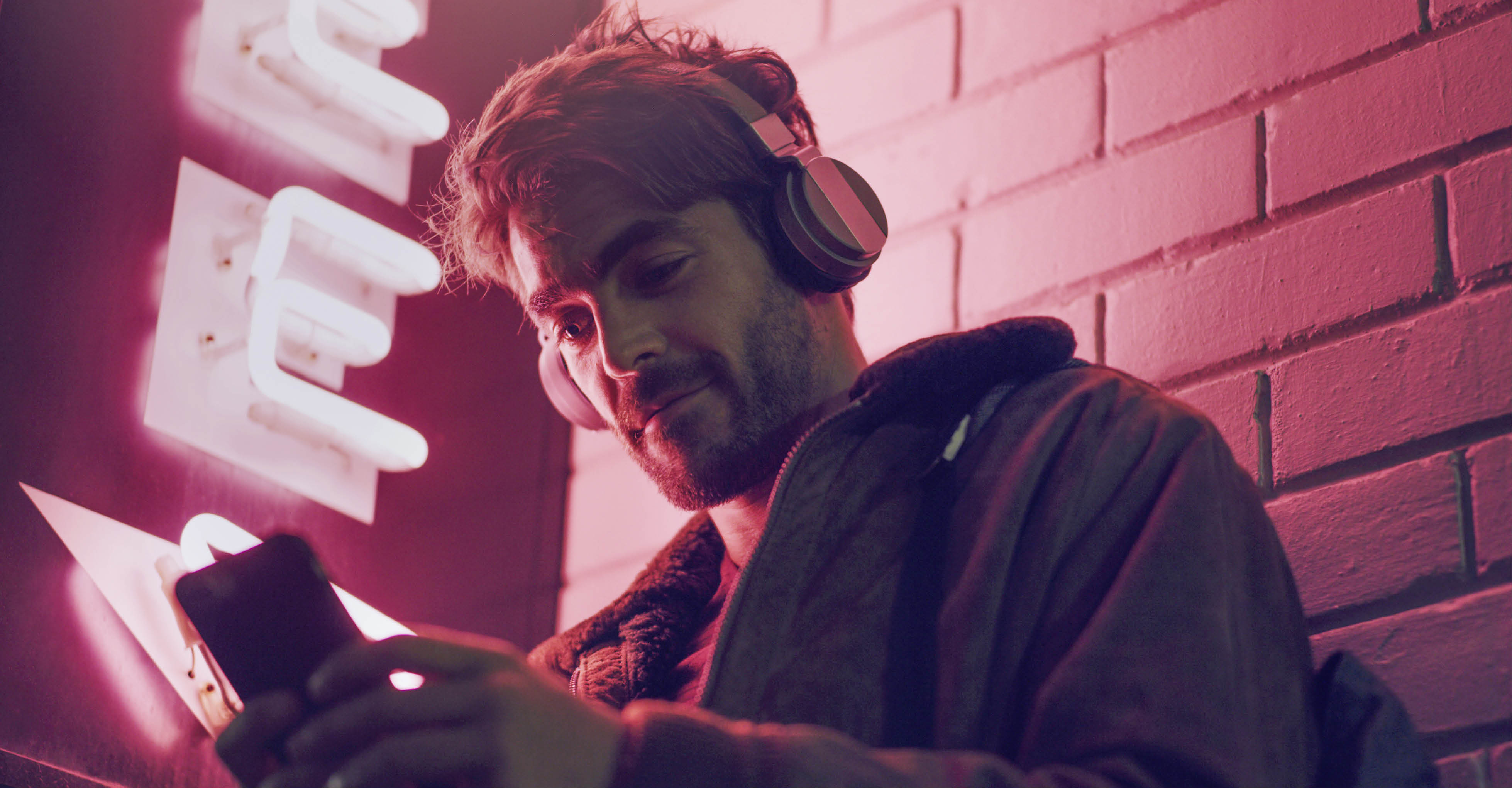 Mann hört mit Kopfhörern App über Smartphone