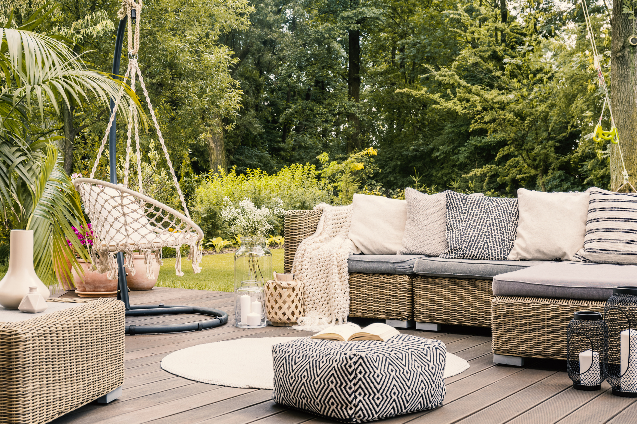 Eine elegante Rattan-Garnitur auf einer Terrasse mit Blick auf einen üppigen Garten