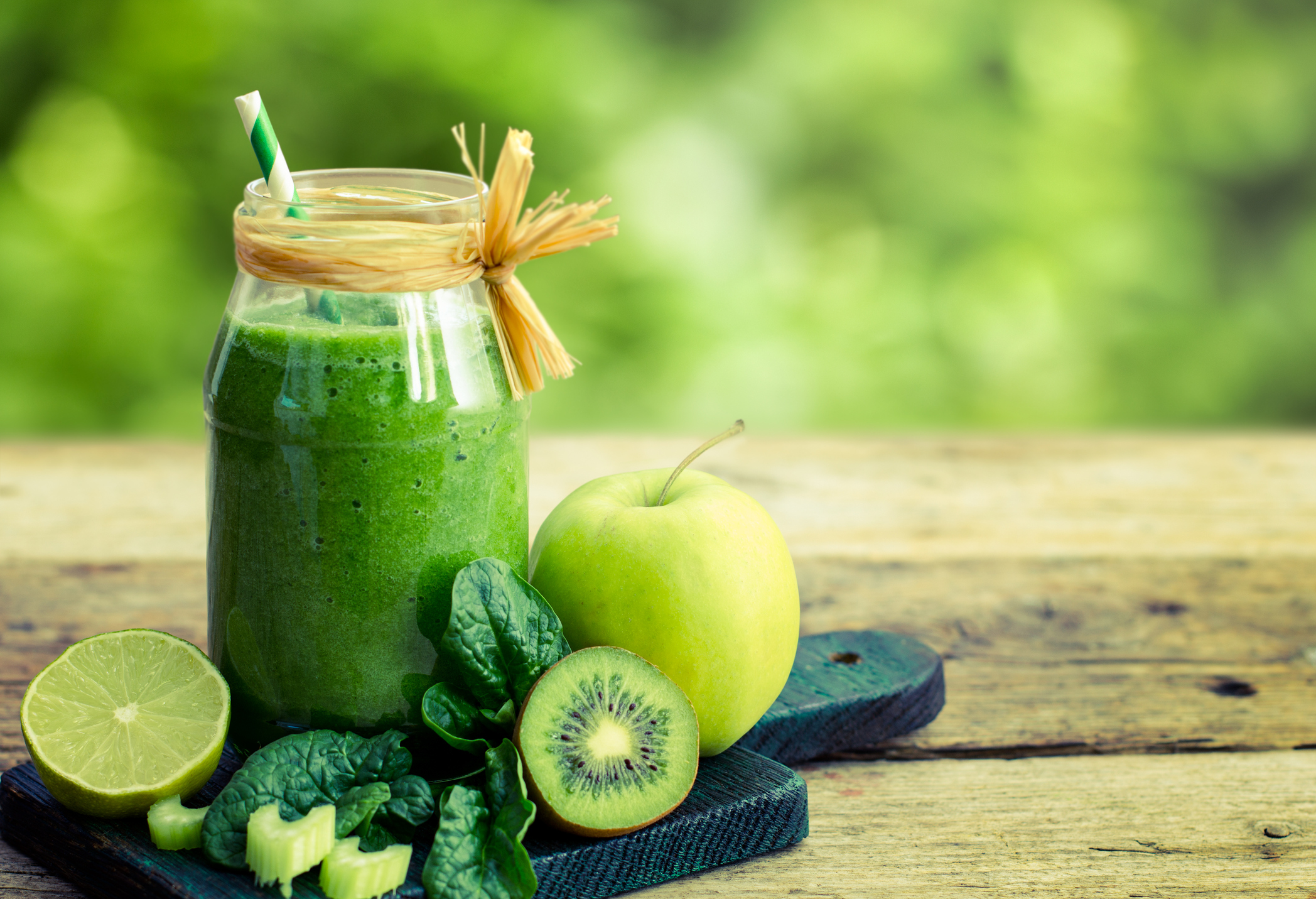 Ein grüner Detox-Smoothie aus Äpfeln, Zitronen und Kiwis in einem Glas mit Strohhalm