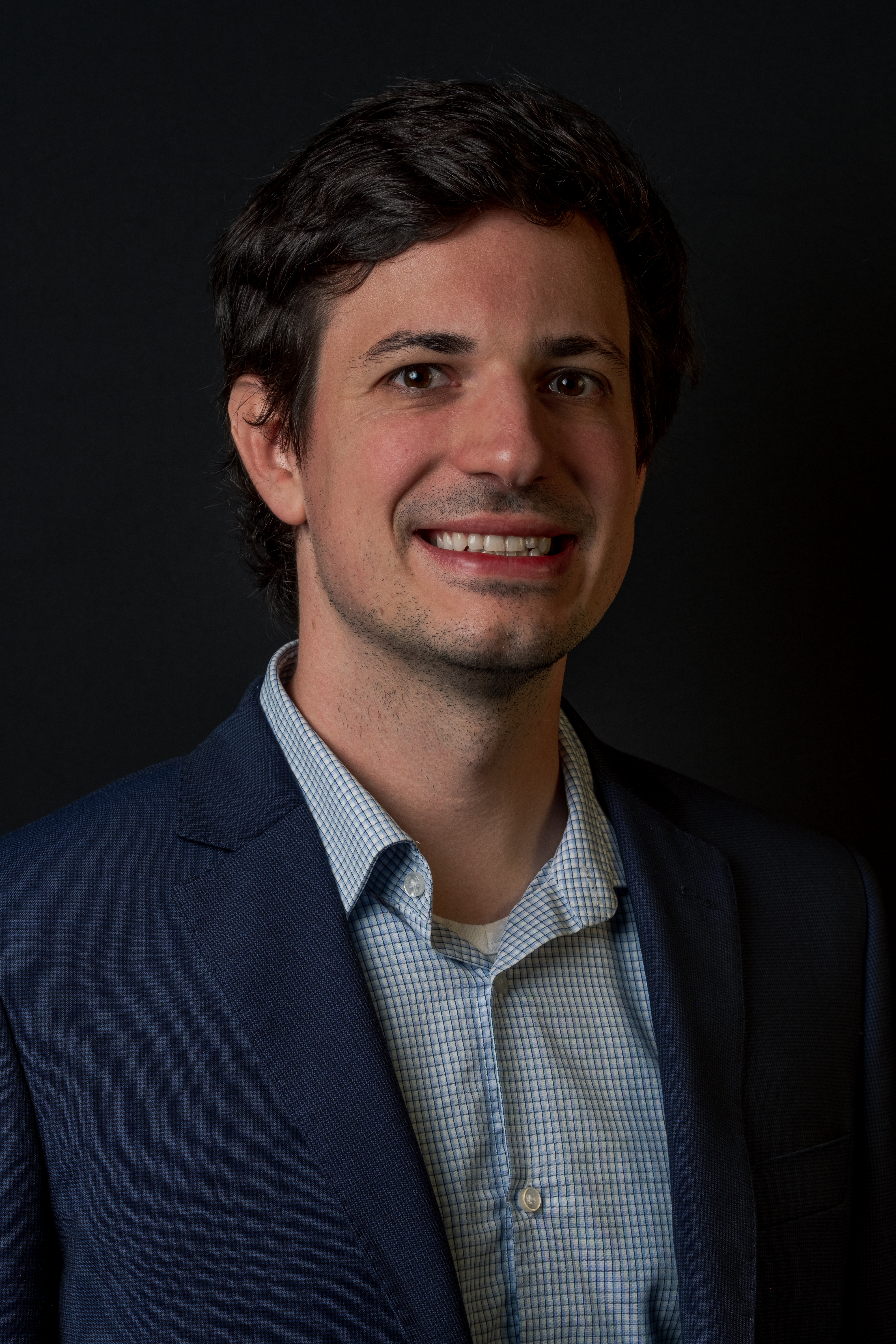 Ein Porträt des Bitmovin Gründers Stefan Lederer in blauem Sakko und weiß-blau karriertem Hemd