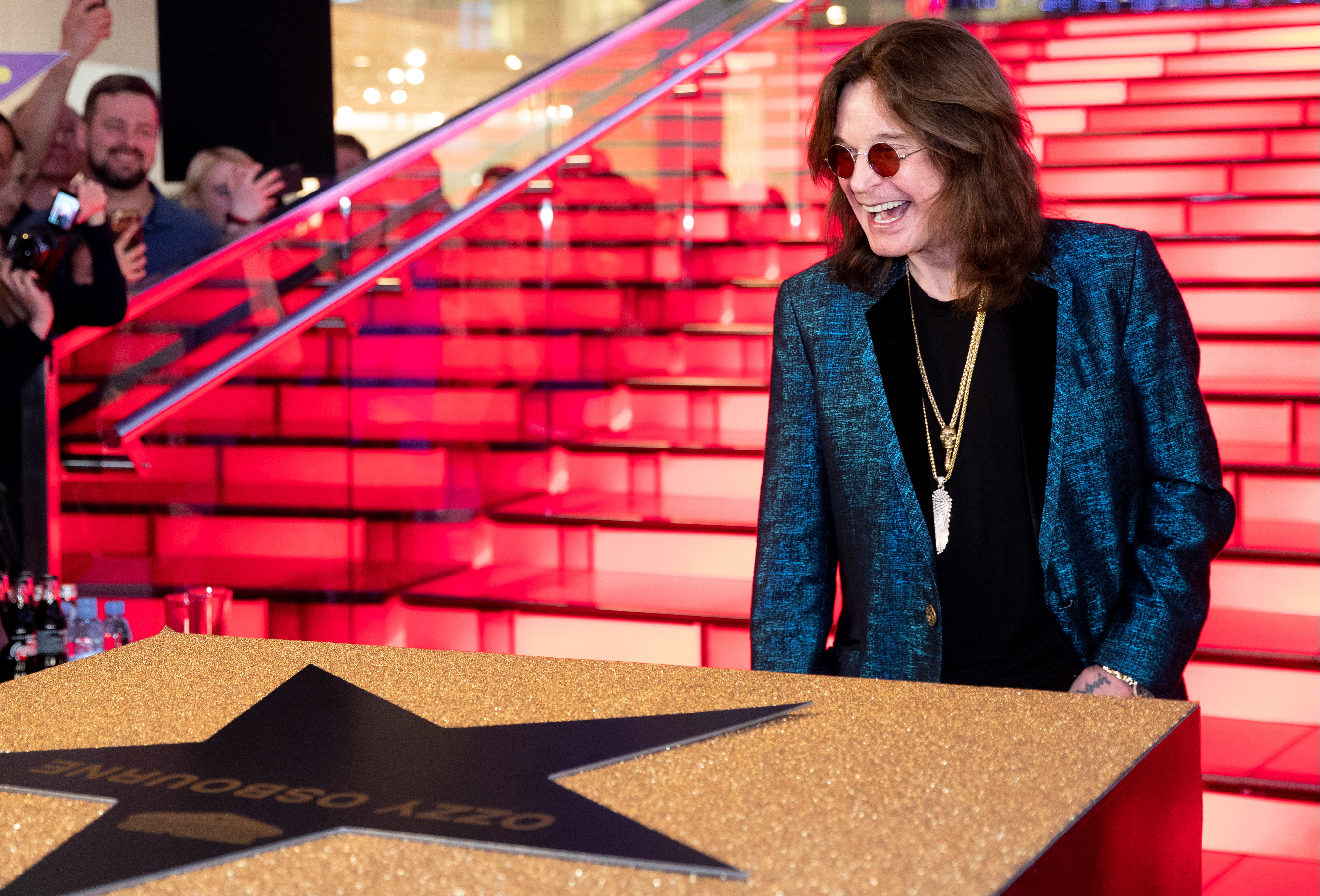 Ozzy Osbourne lachend vor einem Hollywood Stern