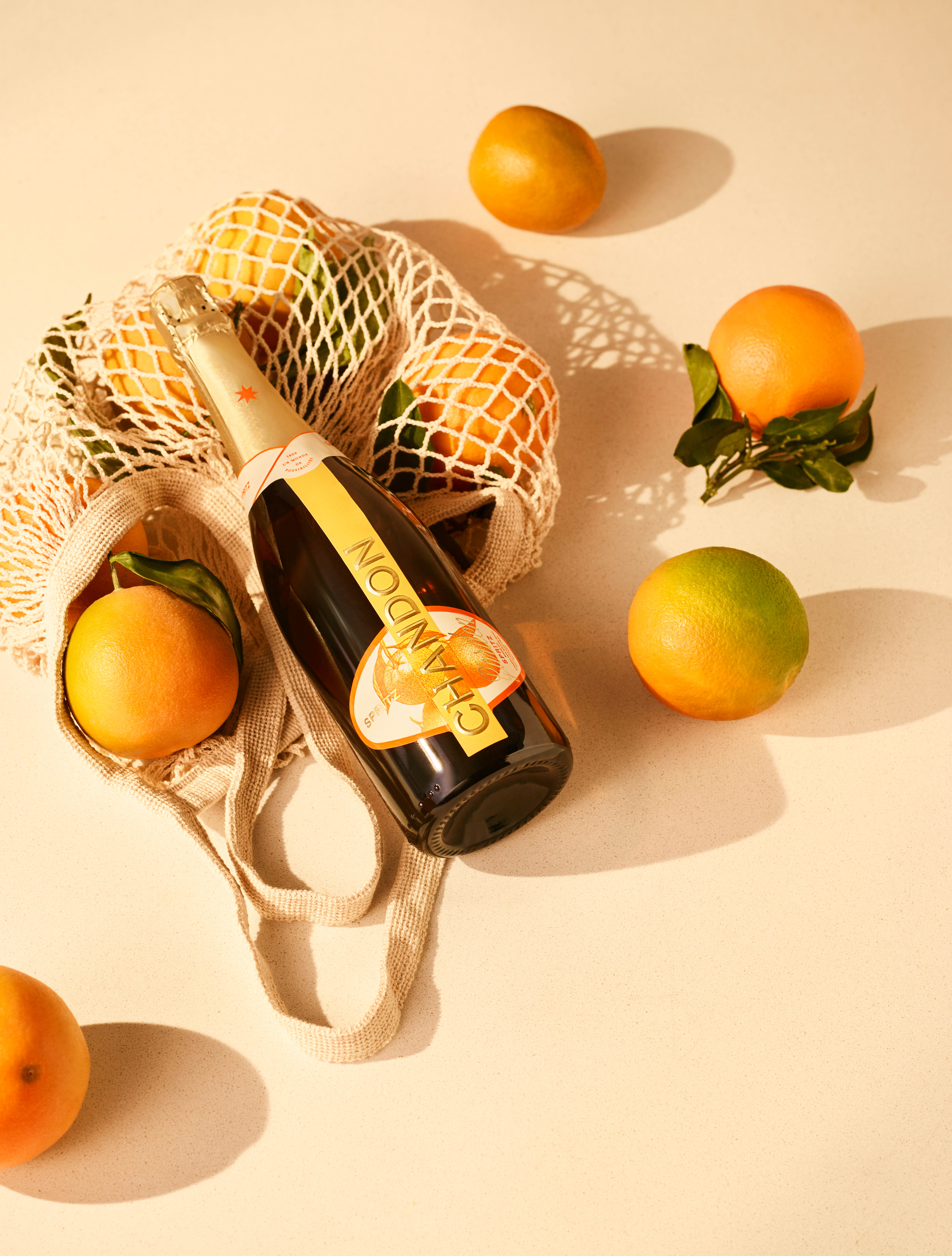 Flasche Chandon Garden Spritz plus Einkaufsnetz und Orangen