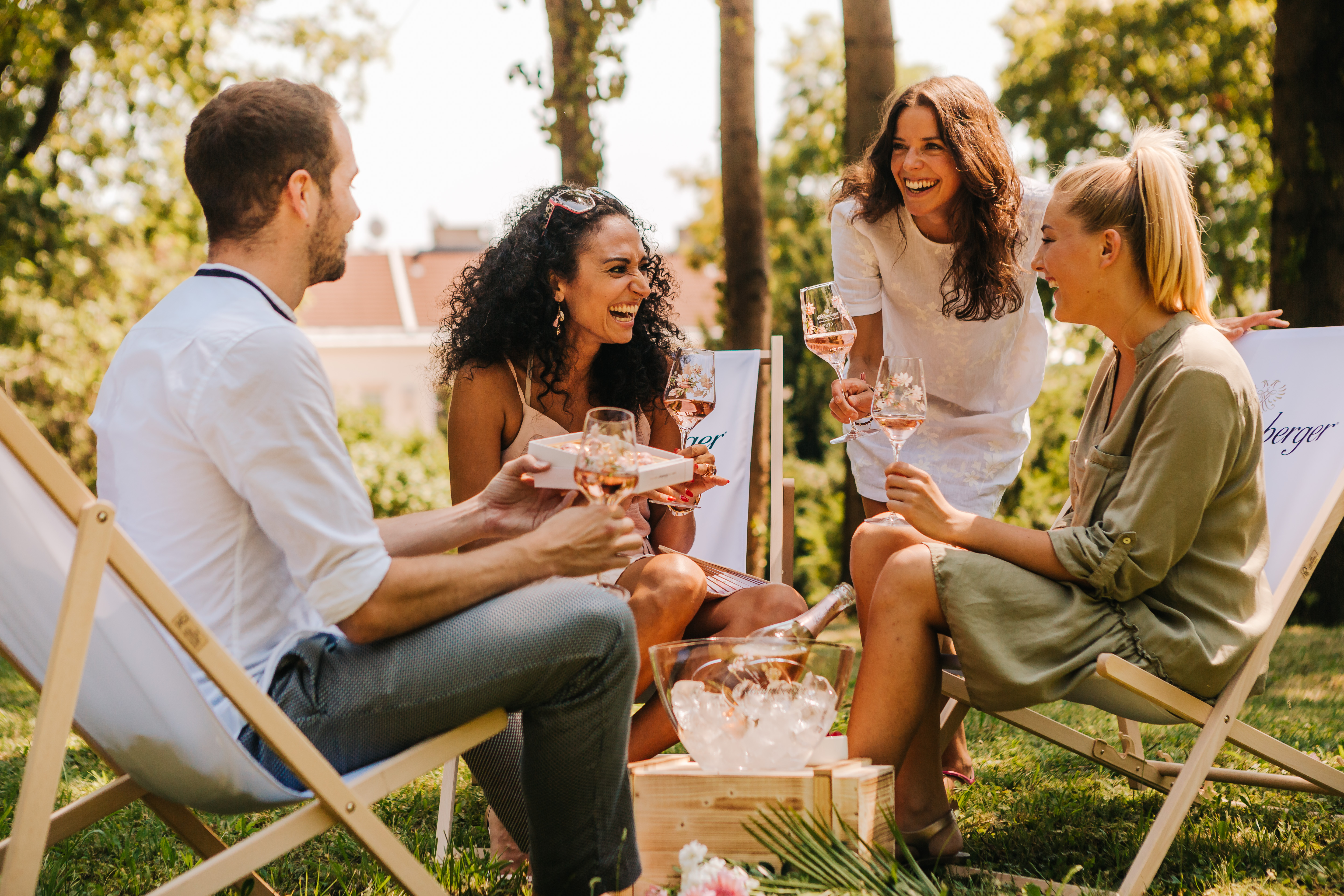 Freundesrunde trinkt im Garten Sekt