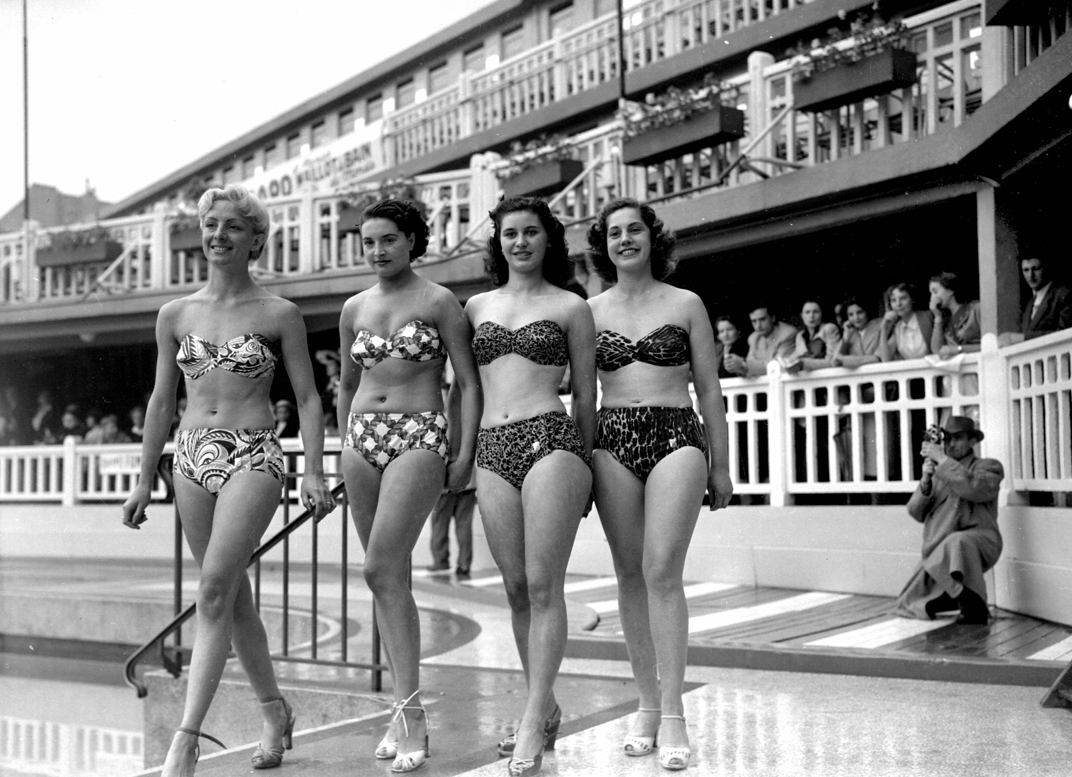 Vier Frauen präsentieren Bikinis in einem Schwimmbad