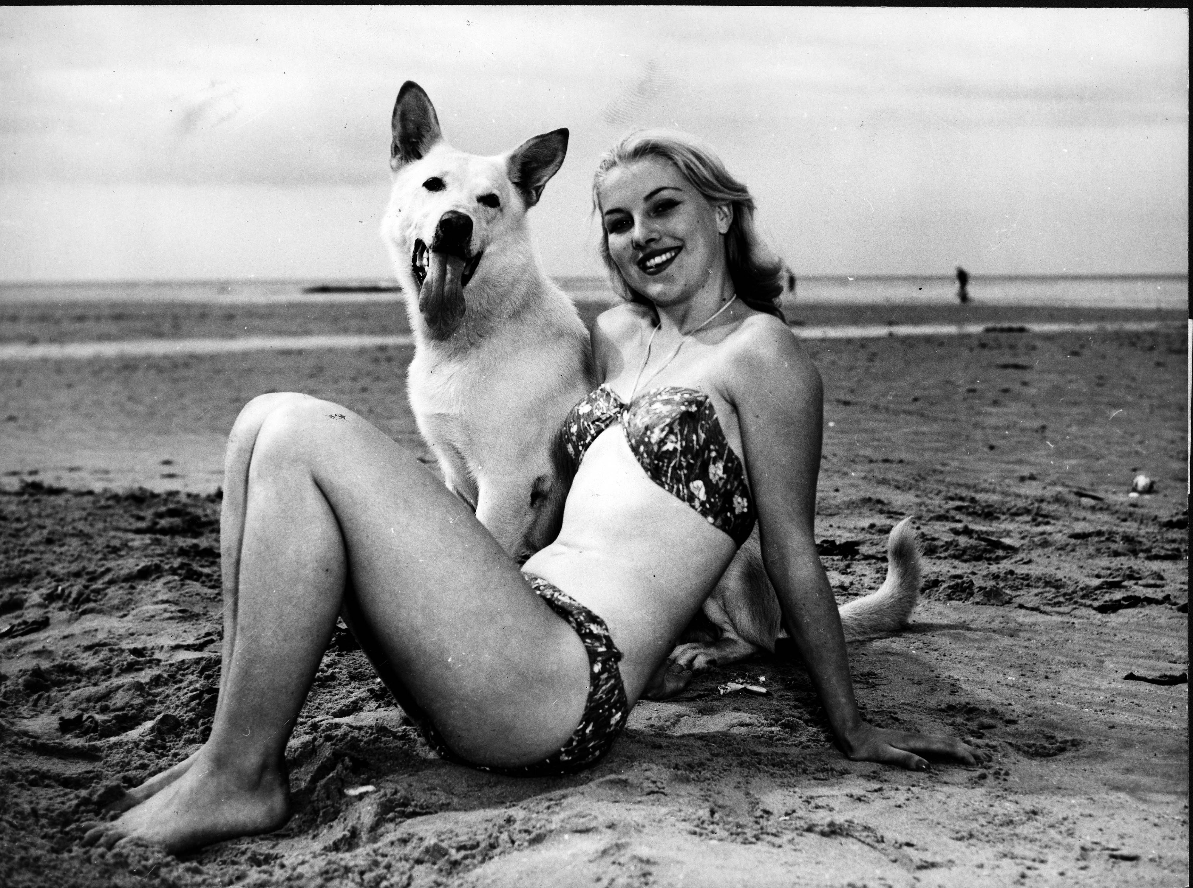 Model und Hund posieren am Strand