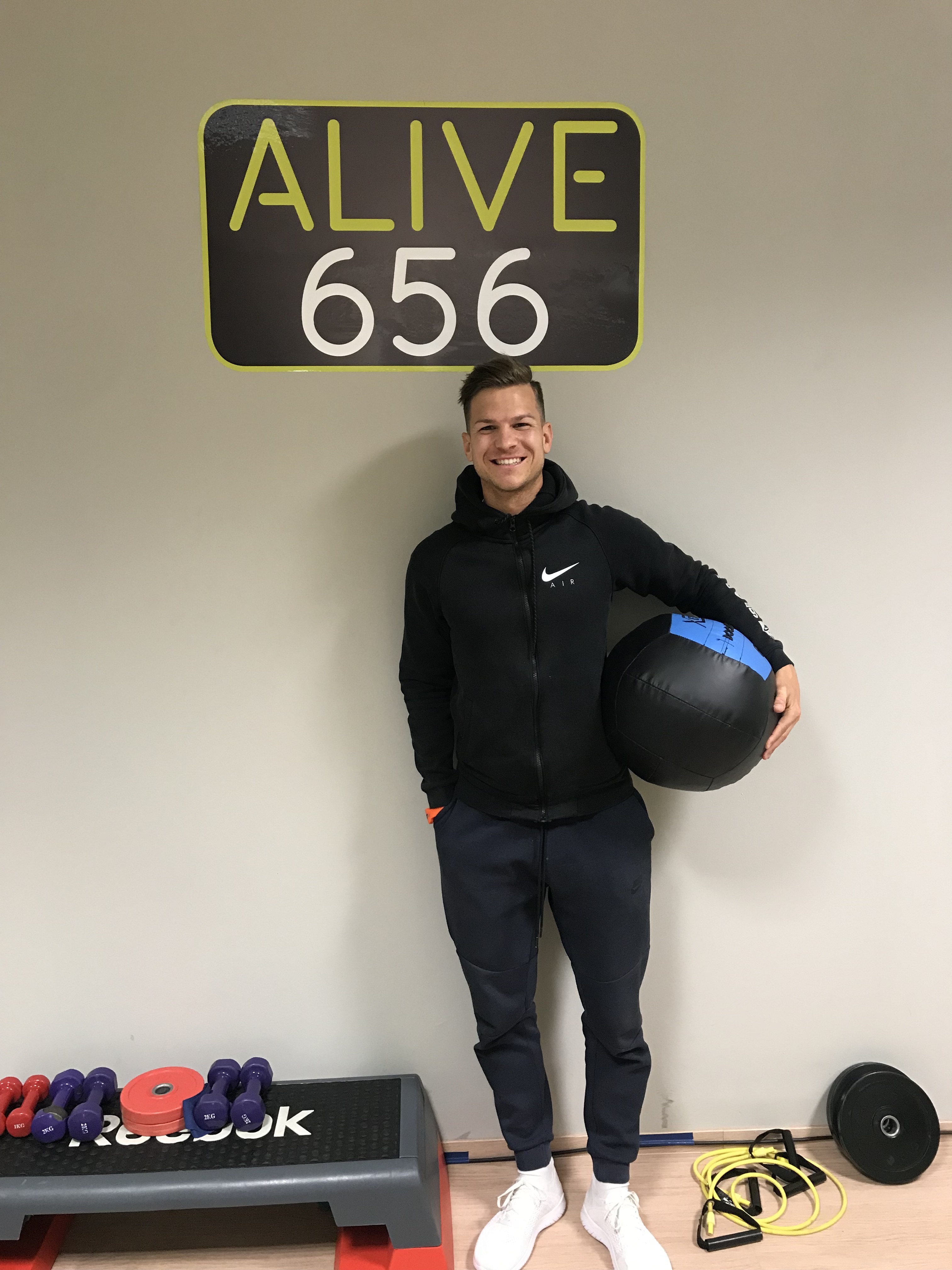 Der Inhaber des EMS Fitnessstudios Alive656, Daniel Mair, mit einem Medizinball unter dem Arm in seinem Fitnessstudio