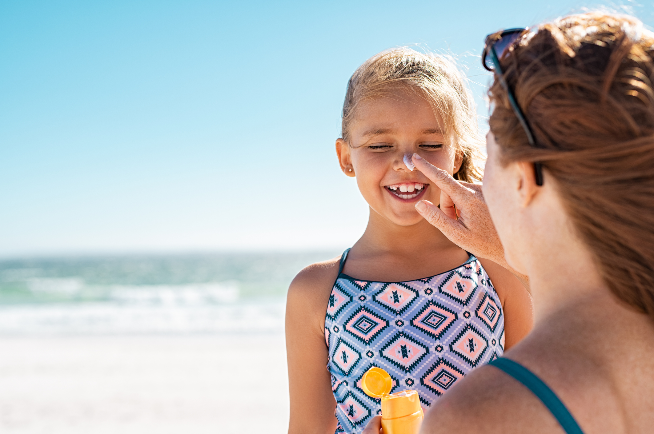 Junge Mutter am Strand mit Kind