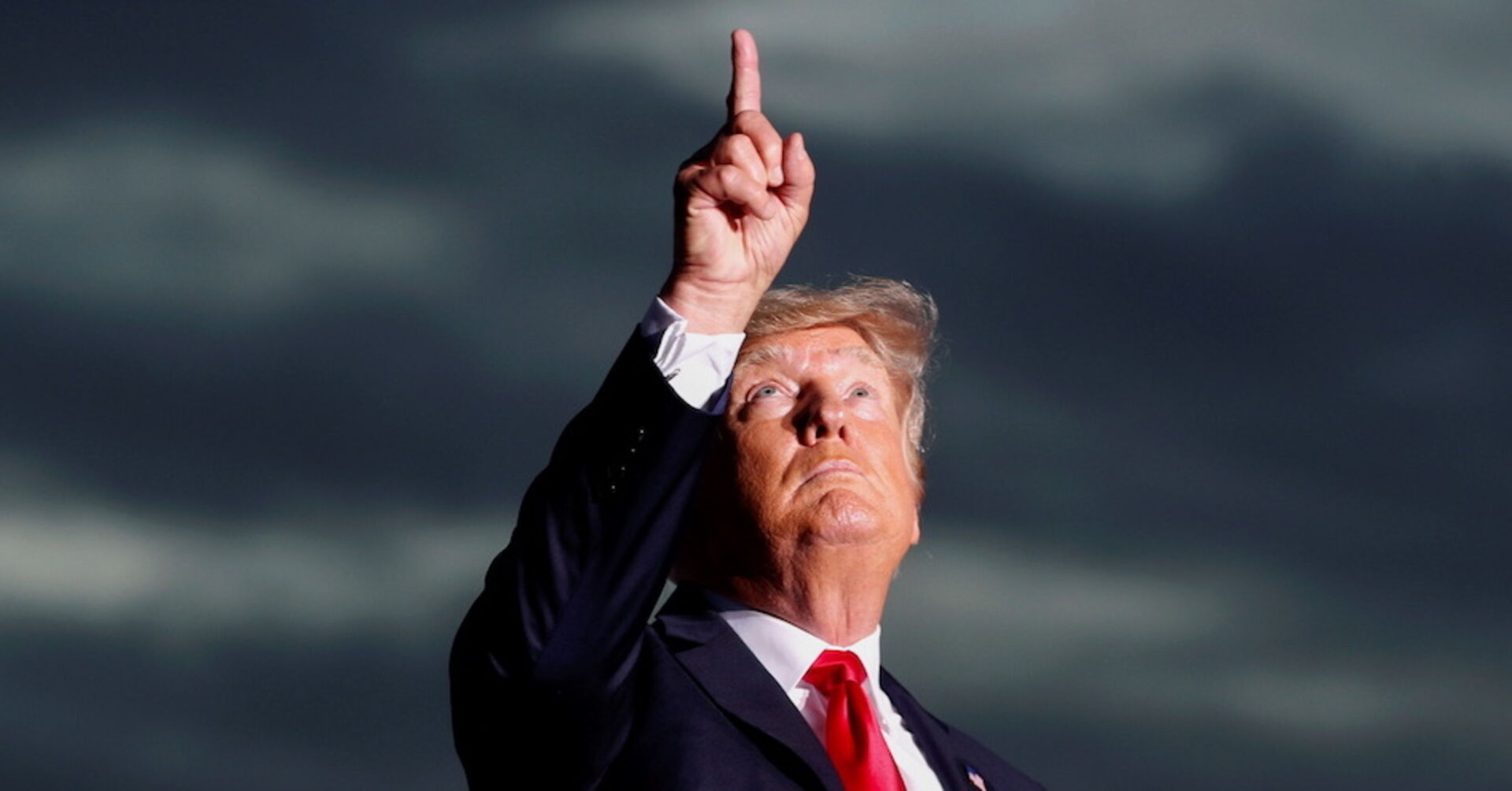 Ex-US Präsident Trump am Rednerpult vor dunklen Wolken