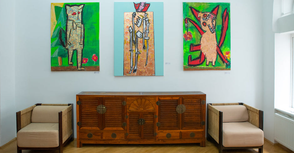 Drei Werke des Künstlers Lukas Soldo an einer wand über zwei Sesseln