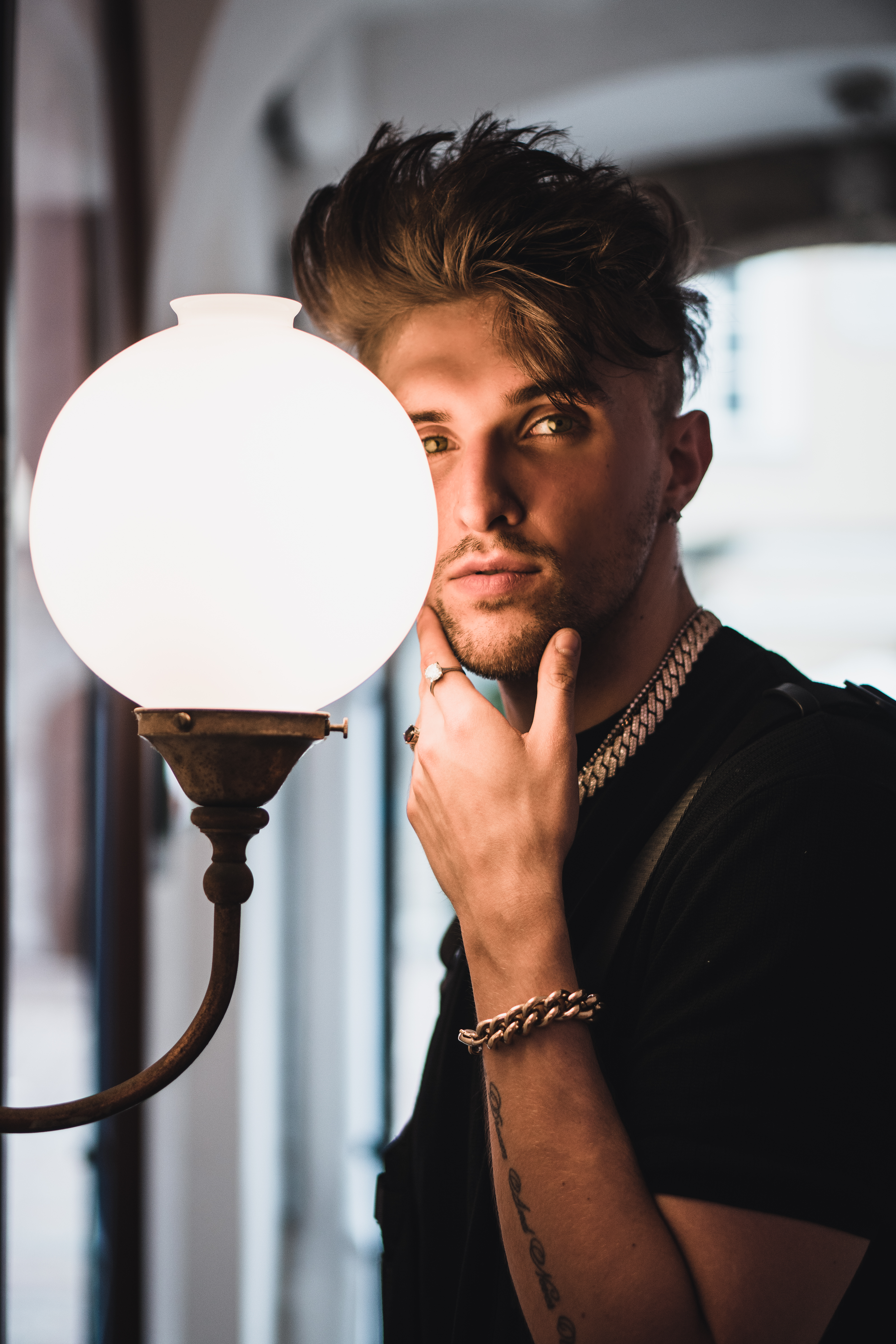 Porträtfoto von Gavis Dean, dessen Gesicht von einer Wandleuchte erhellt wird