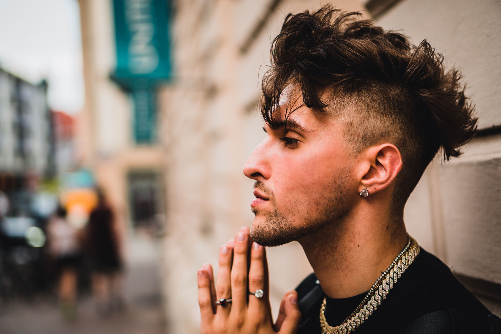 Profilfoto des jungen Rappers Gavis Dean, der an einer Gebäudefassade lehnt