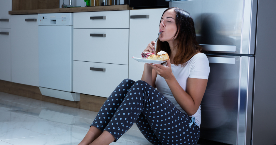 Frau sitzt am Küchenboden und genießt ihr Essen | Credit: iStock.com/AndreyPopov