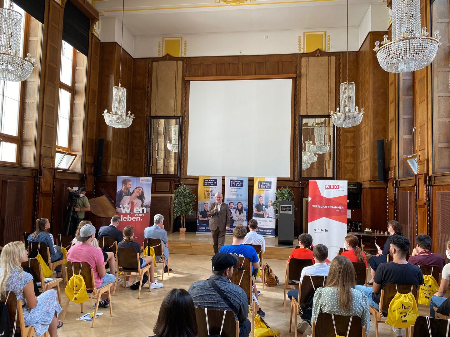 Festsaal der Vienna Business School mit SchülerInnen und Vortragendem