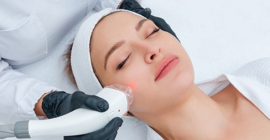 Eine Gesichtsbehandlung mittels Laser durch Expertin mit Einweghandschuhen