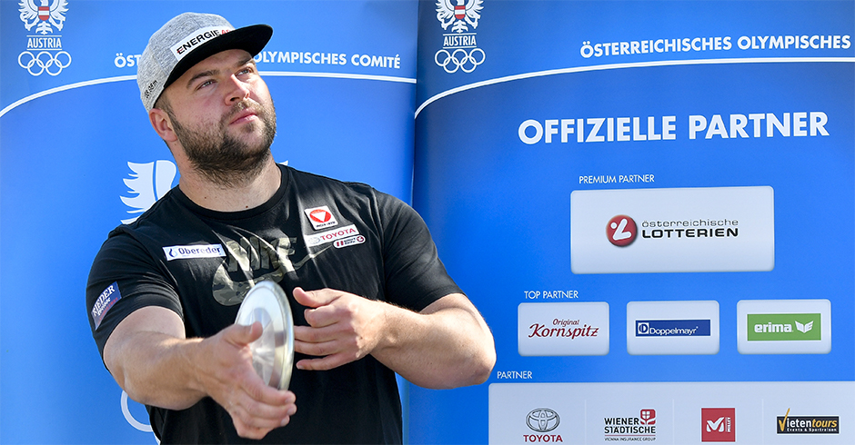 Lukas Weißhaidinger mit schwarzem Shirt und grauen Cap bei der offiziellen Vorstellung des österreichischen ÖOC-Kaders mit einem Diskus in der Hand.