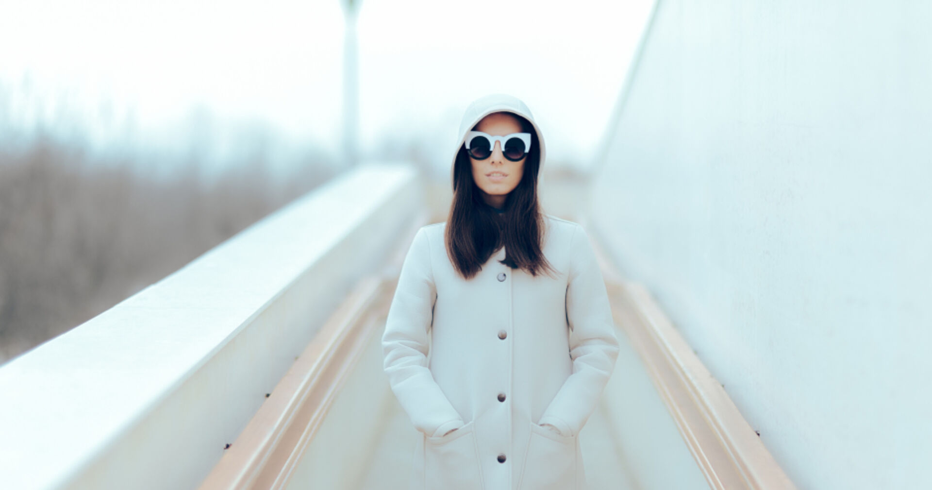 Urban Street Style - cool in Szene gesetzt mit weißem Stehkragenmantel vor herbstlich-nebeliger Kulisse | Credit: iStock.com/nicoletaionescu