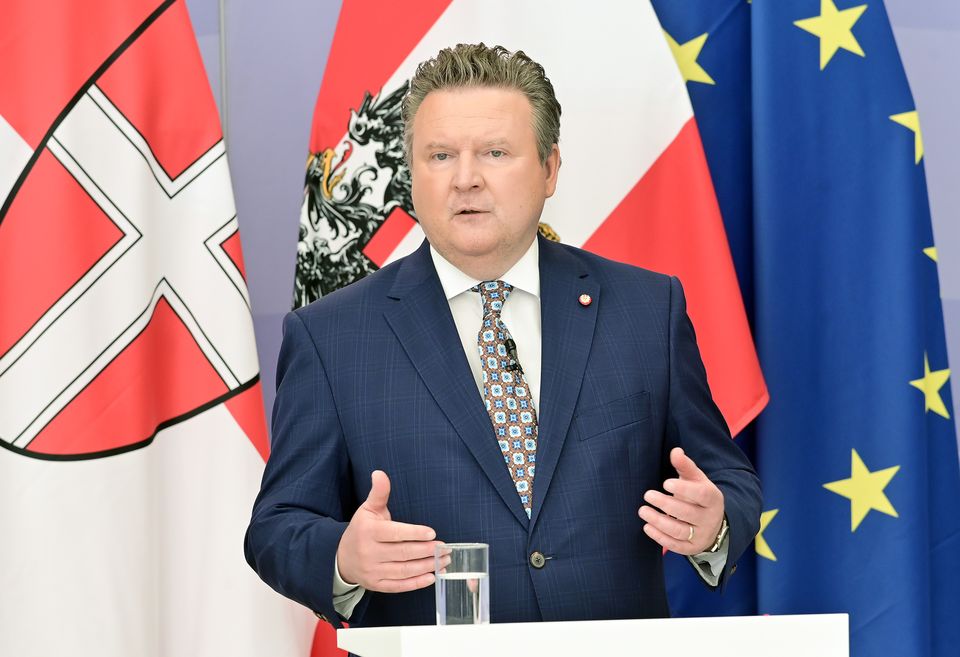 Bürgermeister Michael Ludwig steht vor einer Wien-, Österreich und EU-Flagge und erklärt die Maßnahmen.