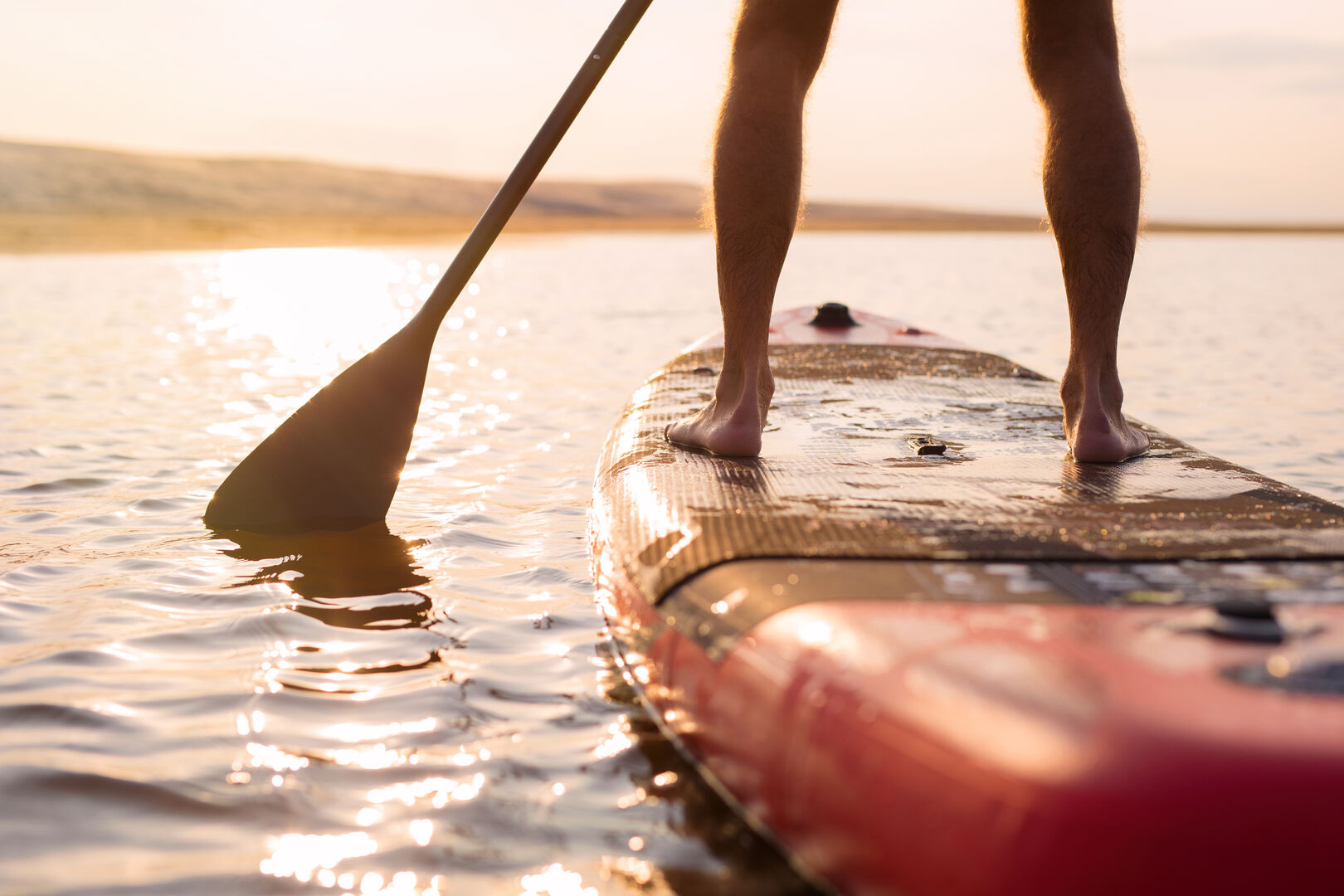 Eine Person stehend am Stand-Up-Paddling-Board