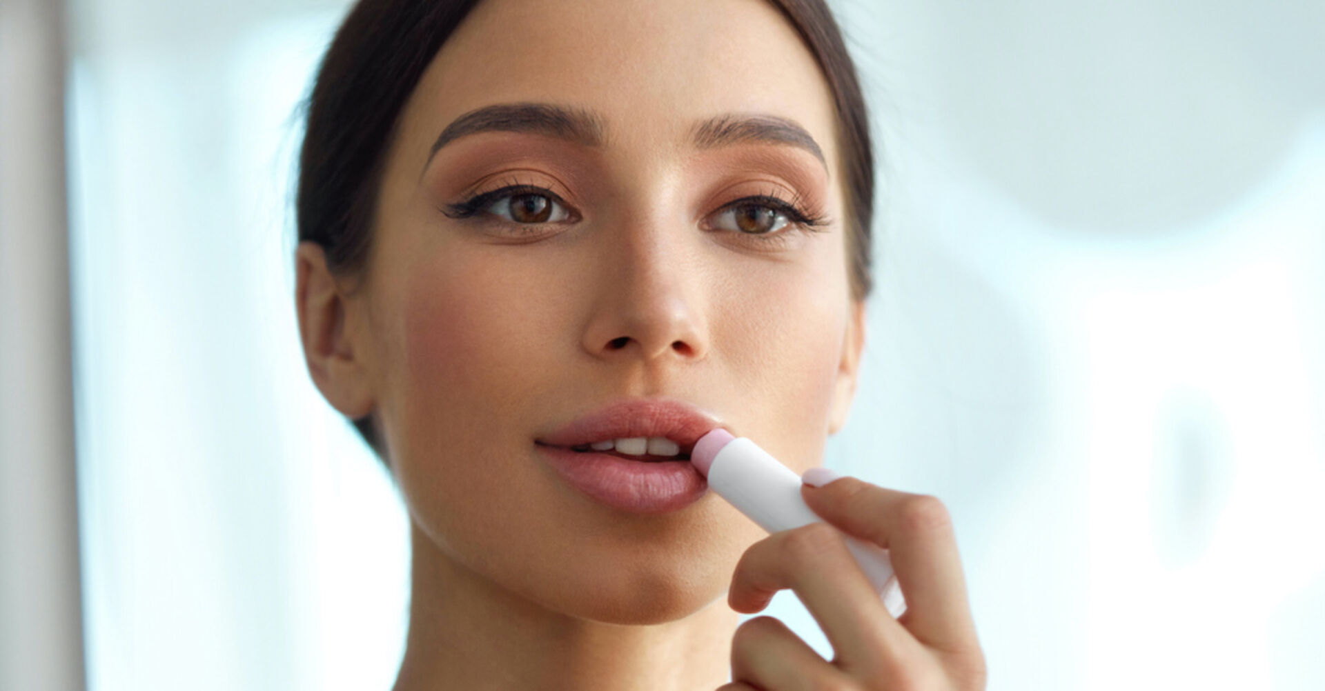 Junge hübsche Frau zieht sich Lippen nach I Puhhha/istockpictures.com