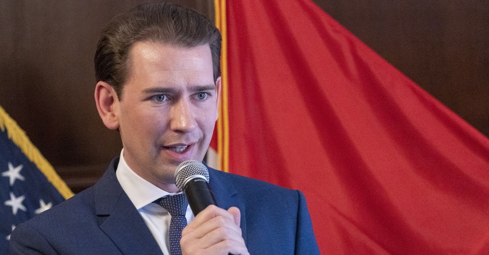 Bundeskanzler Sebastian Kurz spricht in ein Mikrofon. Hinter ihm die amerikanische und die österreichsiche Flagge.