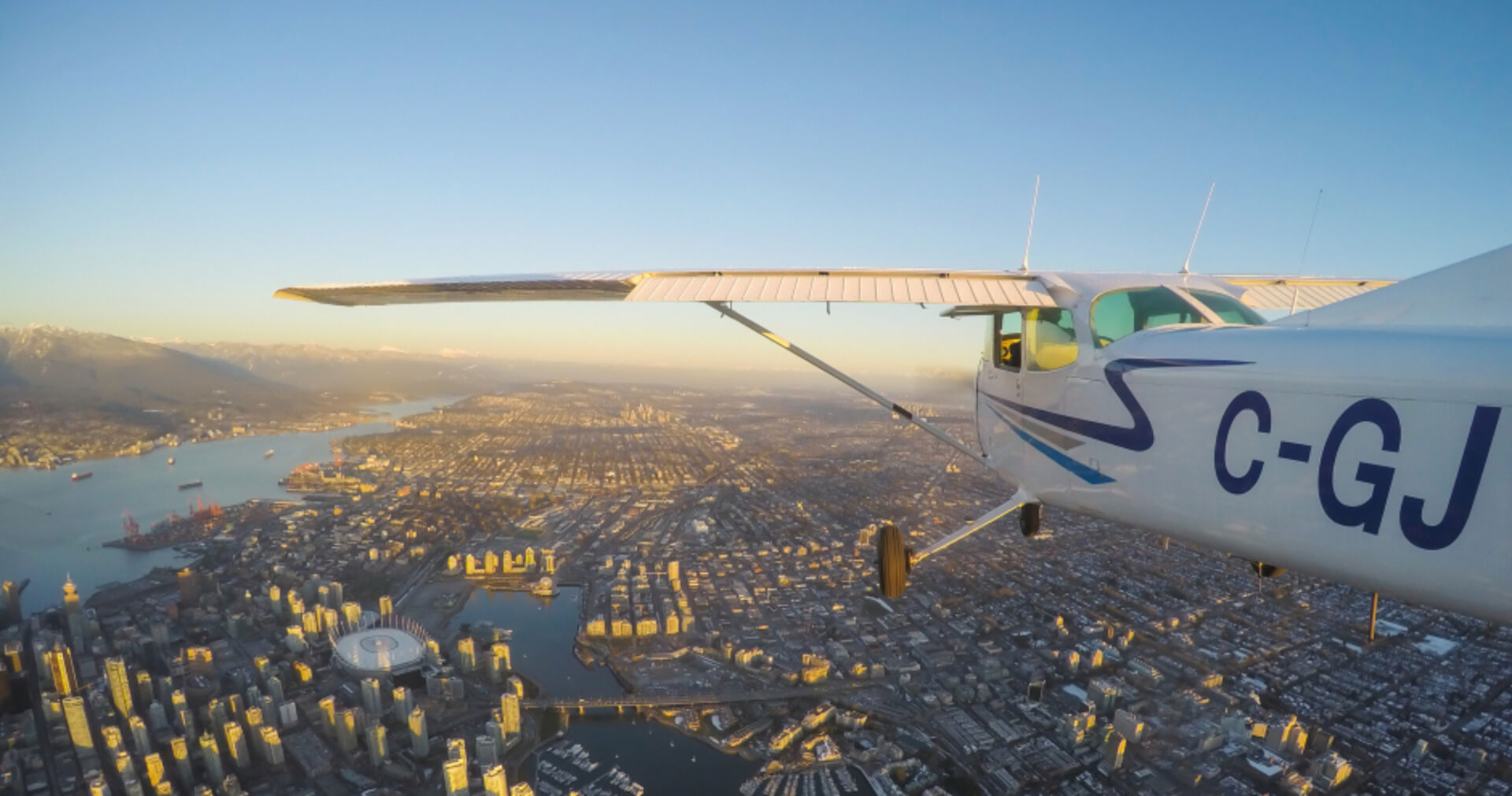 Landeanflug auf große Stadt bei Sonnenuntergang | Credit: iStock.com/edb3_16