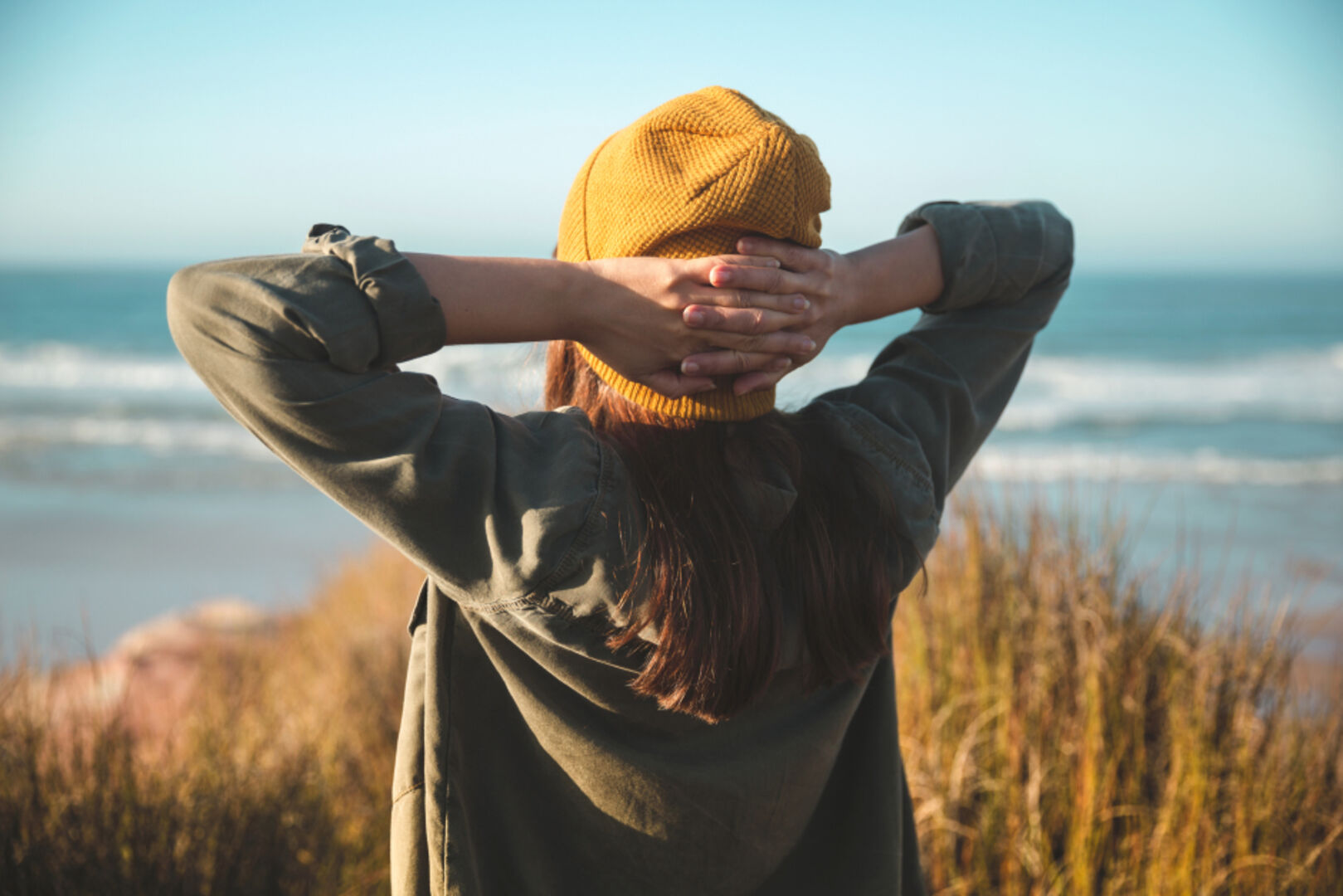 Frau entspannt bei Spaziergang am Strand | Credit: iStock.com/erikreis