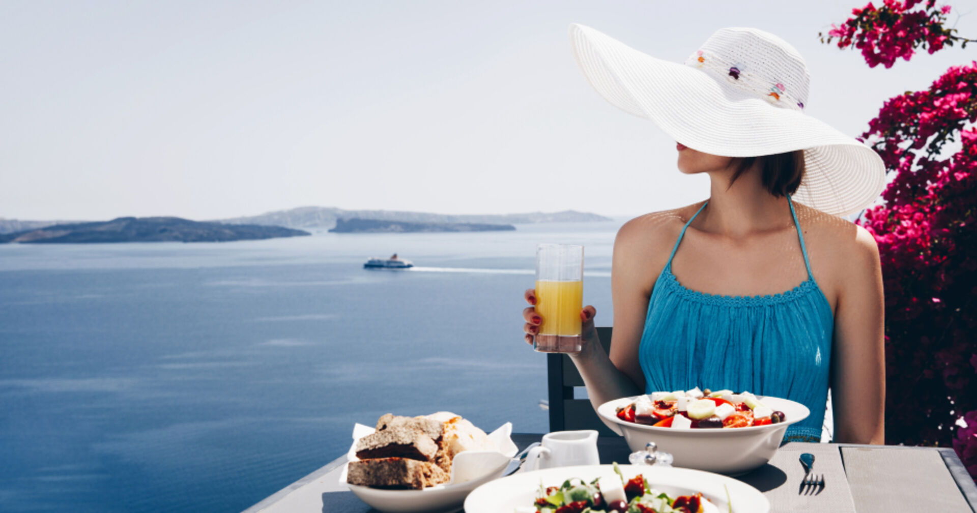 Frau beim Abendessen am Mittelmeer | Credit: iStock.com/katiafonti