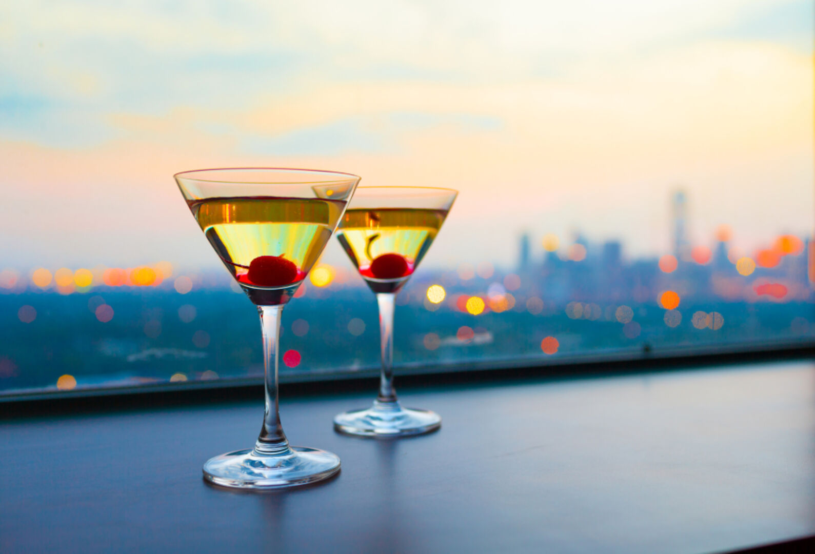 Cocktails über den Dächern einer Großstadt am Ende eines Tages | Credit: iStock.com/kieferpix