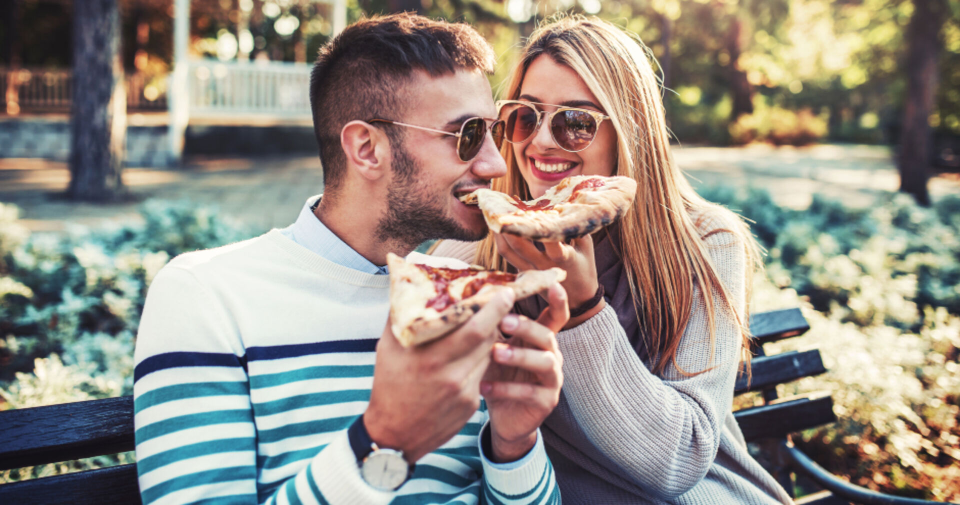 Pärchen beim Pizza-Essen im Park | Credit: iStock.com/Bobex-73