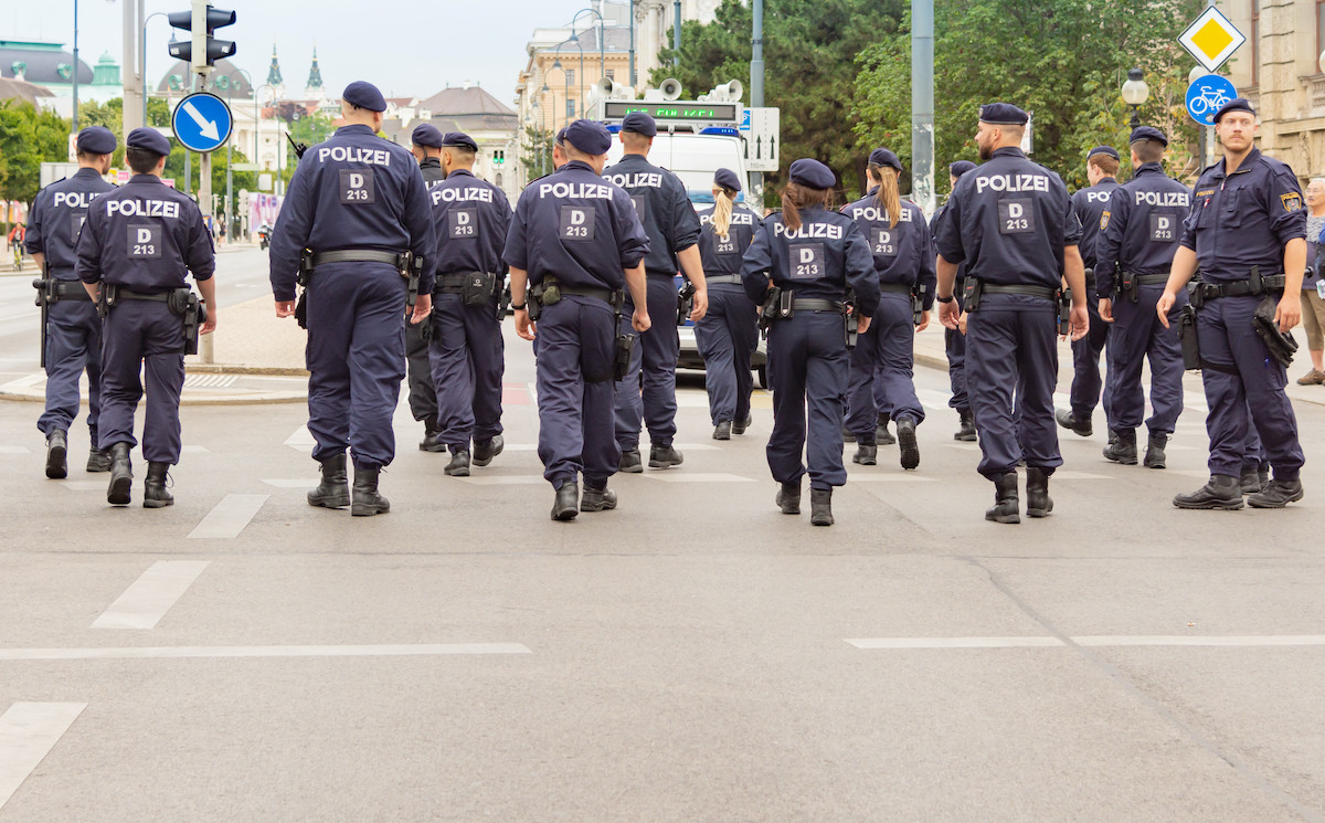 Eine Gruppe Polizisten auf einer Straße, von hinten aufgenommen