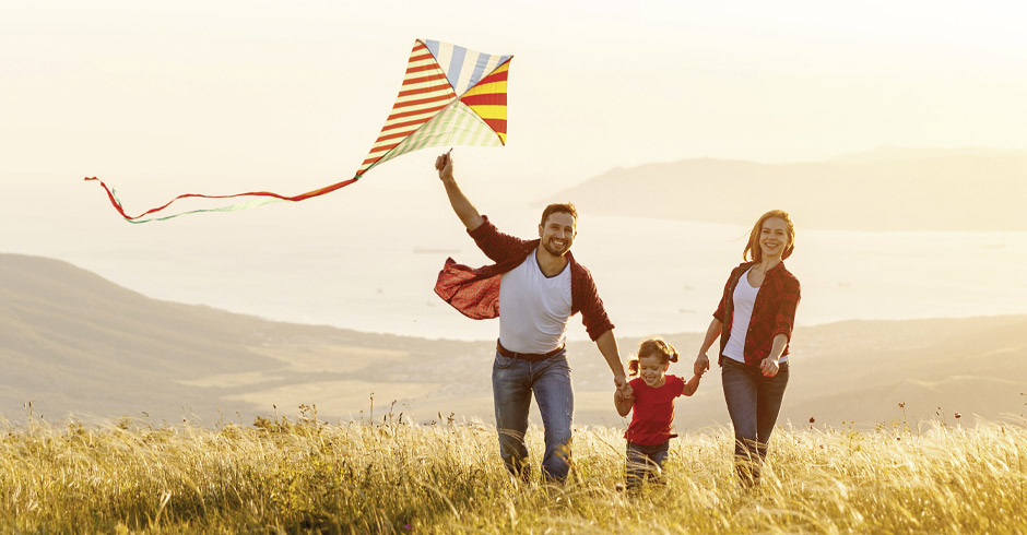 Fröhliche Menschen die einen Drachen steigen lassen