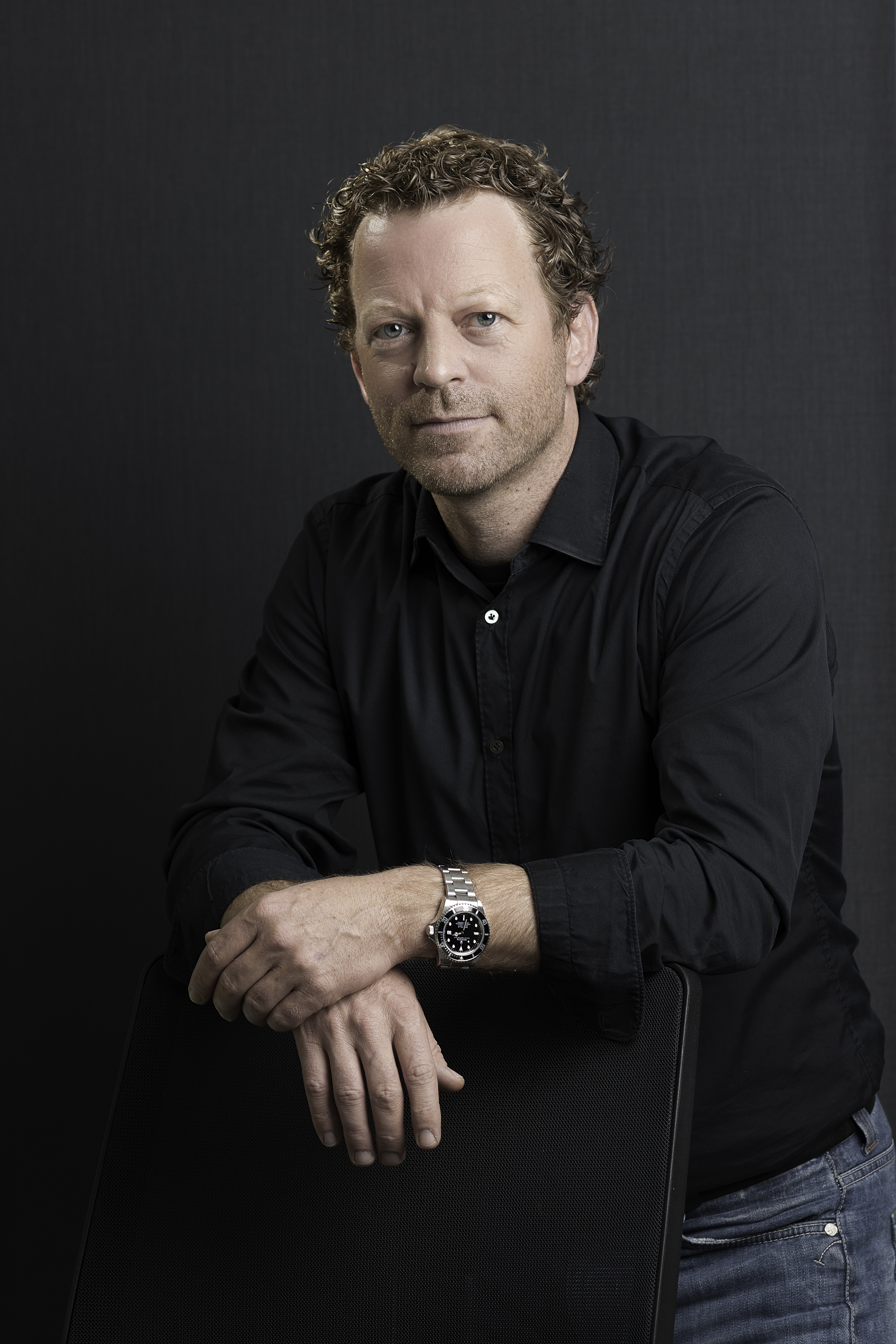 Markus Jordan, der sich mit seinen Händen auf eine Stuhllehne sützt