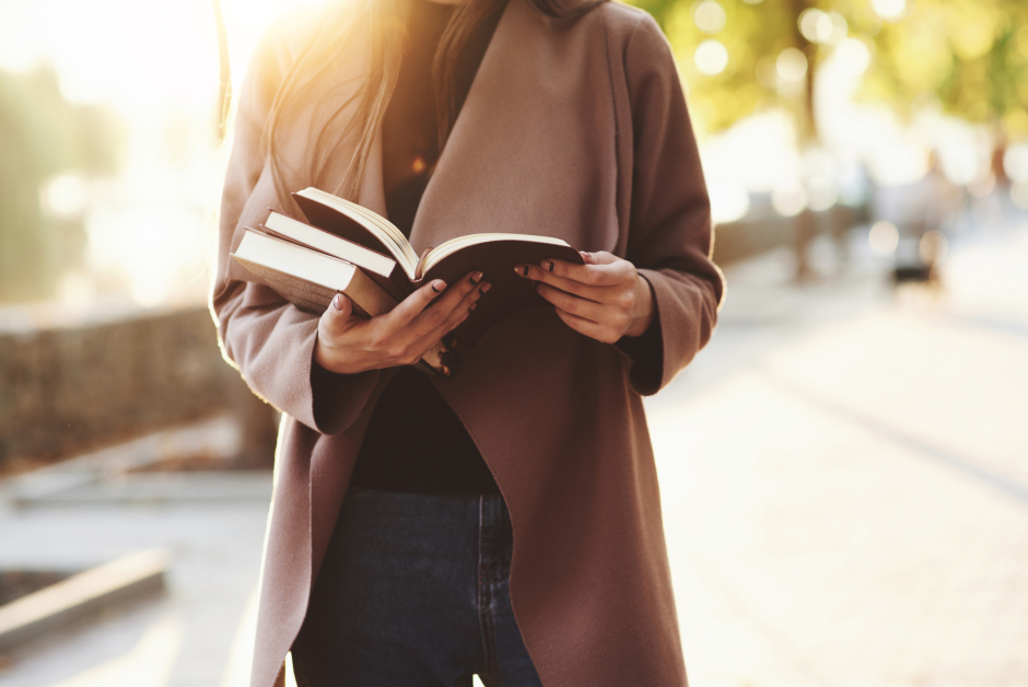 Frau mit offenem Buch in der Hand | Credit: iStock.com/standret