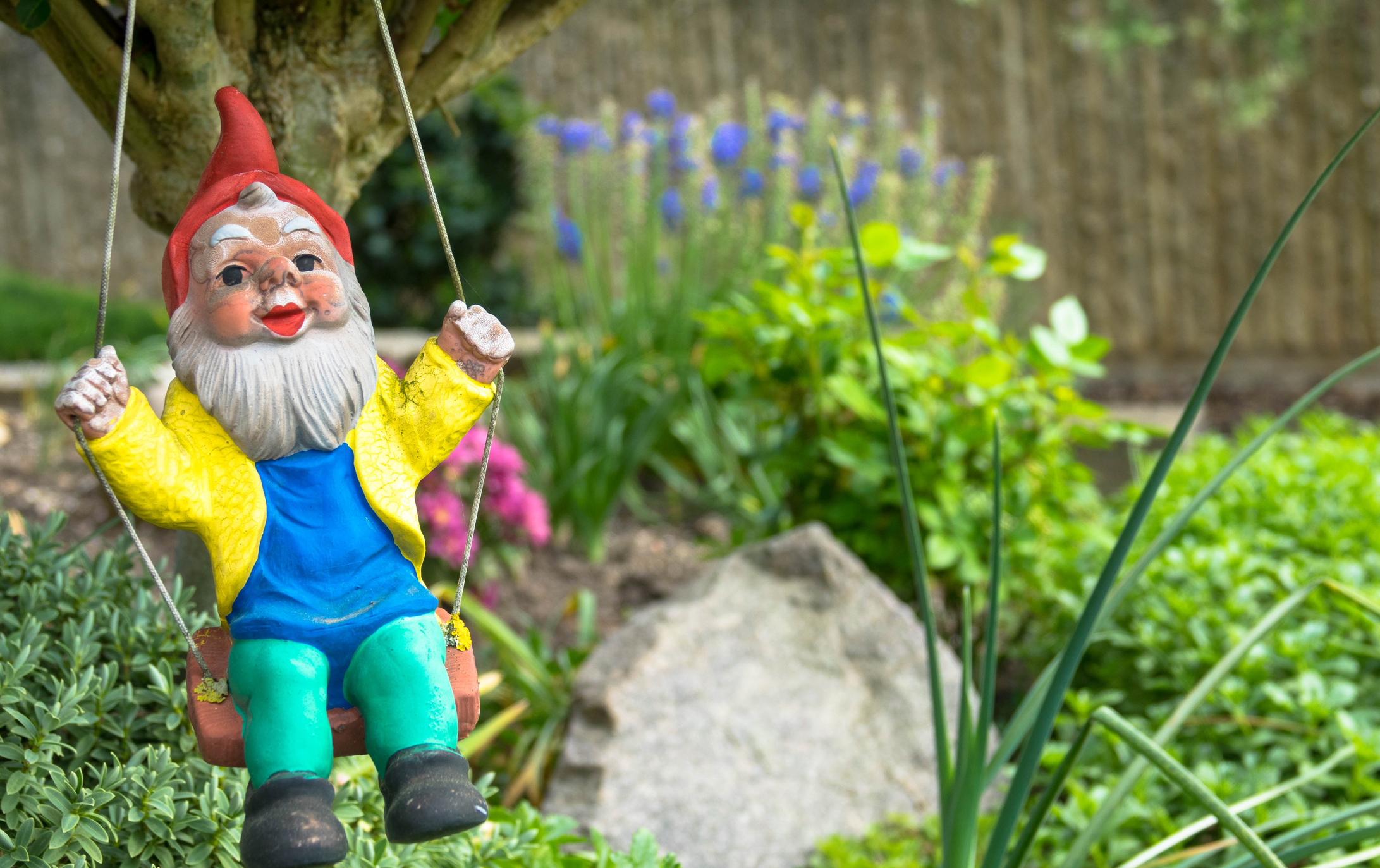 Gartenzwerg auf einer Schaukel | Credit: iStock.com/Einsenlohr