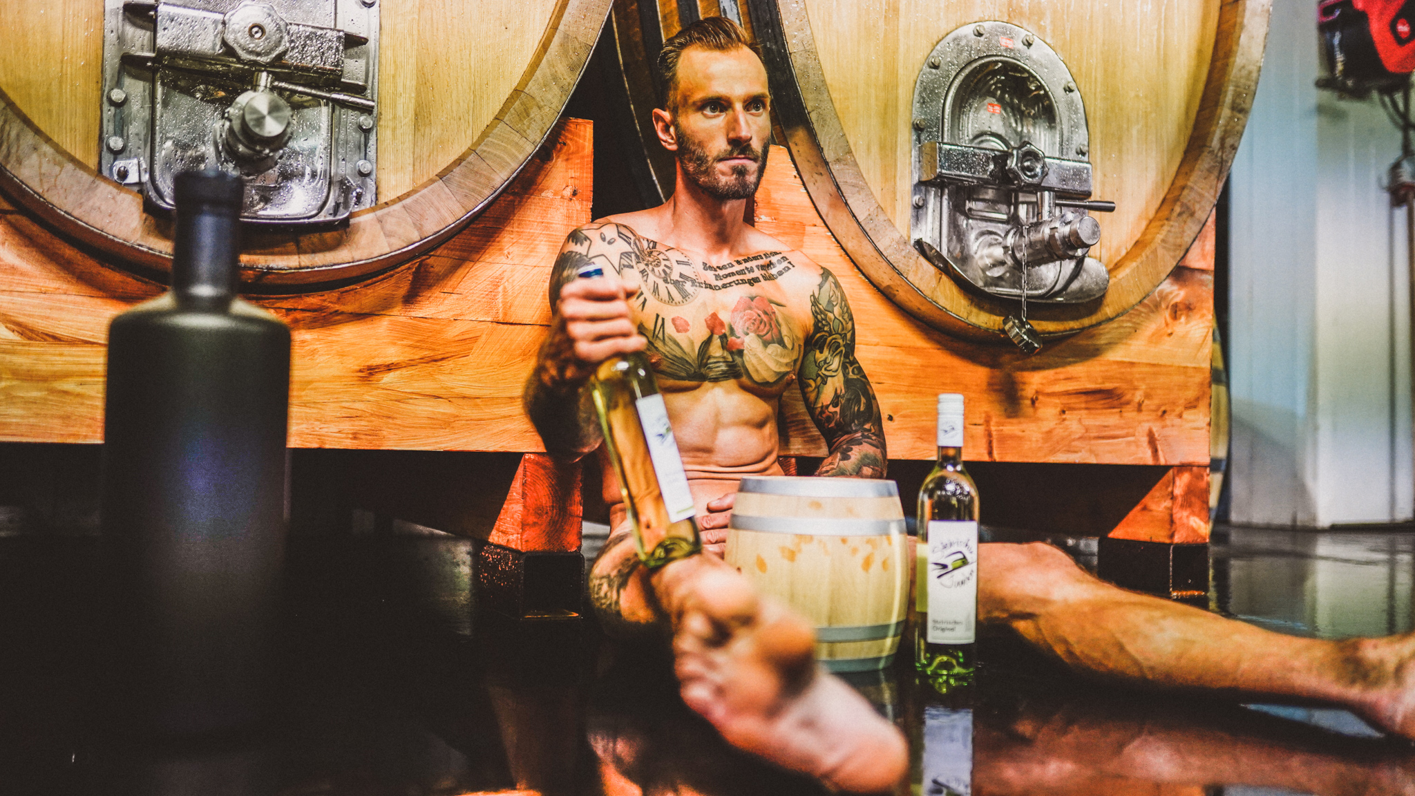 Junger Mann vor Weinfässern