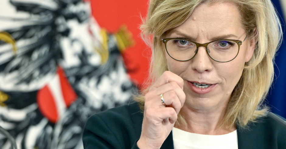 Porträt vor Österreichflagge mit erhobener Hand