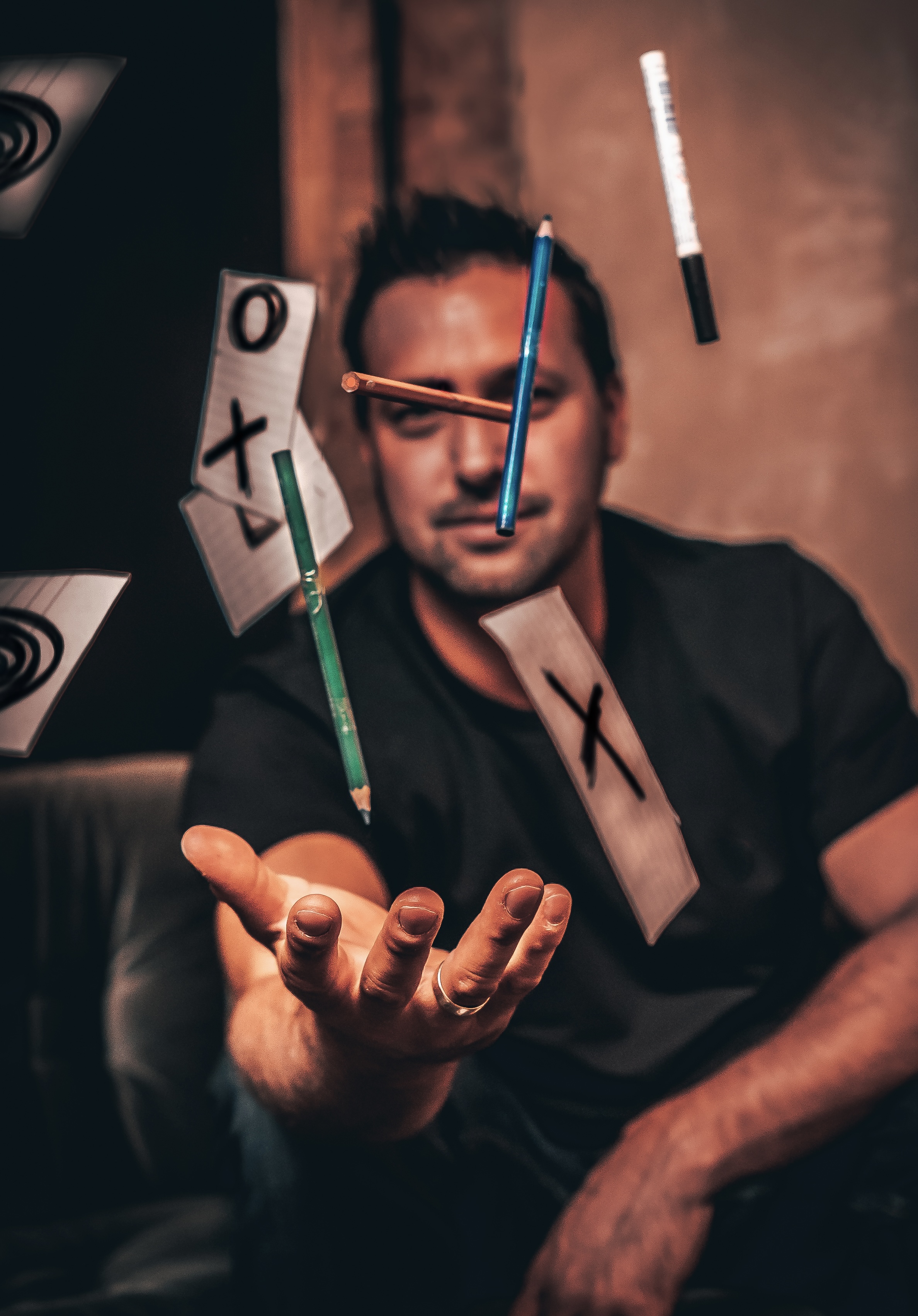 Christoph wirft mit einer Hand Buntstifte in die Luft