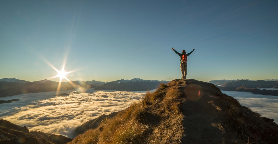 Eine Person die alleine am Gipfel steht.