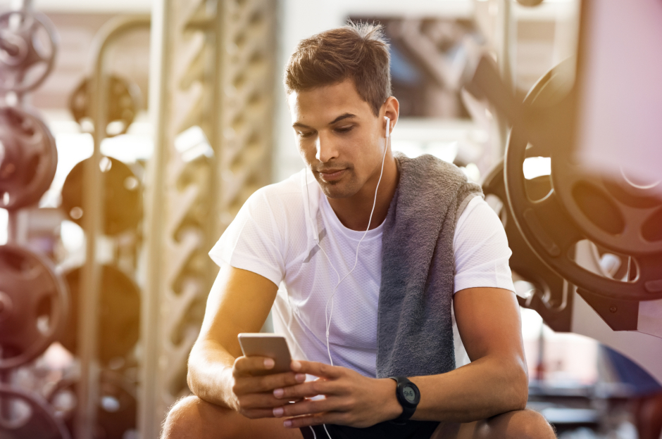 Junger Mann im Fitnessstudio mit In-Ear-Kopfhörern | Credit: iStock.com/Ridofranz