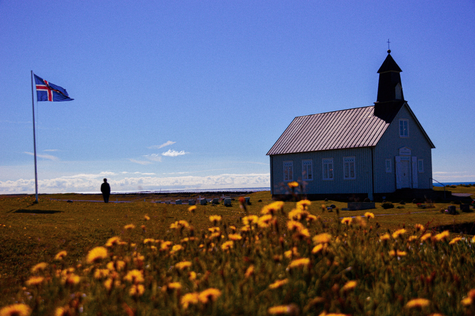 Fahnenmast mit isländischer Flagge vor einer alten Kirche | Credit: iStock.com/Pablo Ana Ibanez