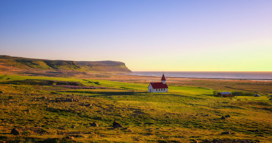 Einsame isländische Landschaft mit Kirche im Licht der untergehenden Sonne | Credit: iStock.com/miroslav_1