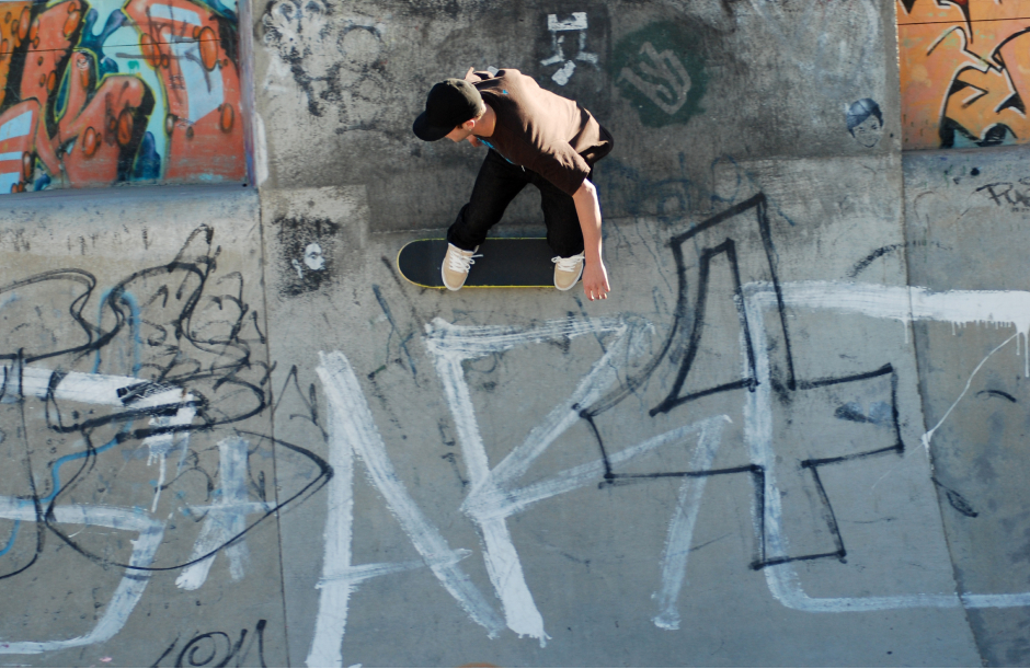 Junger Bursche beim Skateboarden auf einer mit Graffiti besprühten Halfpipe | Credit: iStock.com/Irmine