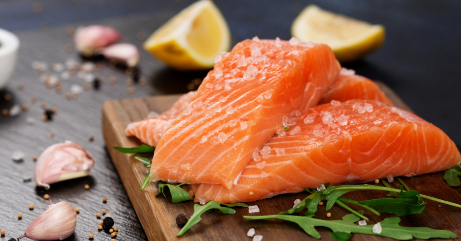 Rohe Lachsfilets mit Knoblauch und Zitrone angerichtet | Credit: iStock.com/Metkalova