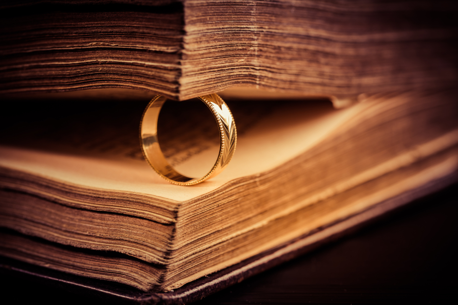 Altes gebundenes Buch mit einem goldenen Ring zwischen den Seiten | Credit: iStock.com/brebca