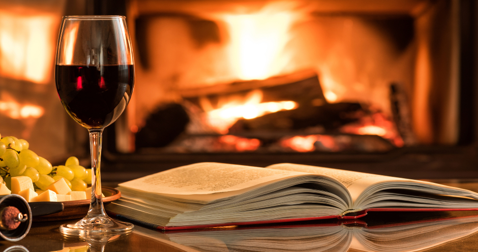 Lesestunde am offenen Kamin mit einem Glas Rotwein | Credit: iStock.com/Rasulovs