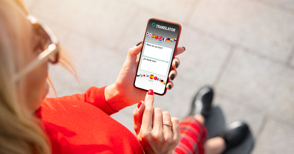 Junge blonde Frau in roter Kleidung geht durch die Straßen, den Blick auf ihr Smartphone gerichtet | Credit: iStock.com/grinvalds