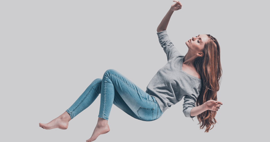 Schwebende Frau in Skinny Jeans und grauem Oberteil | Credit: iStock.com/g-stockstudio