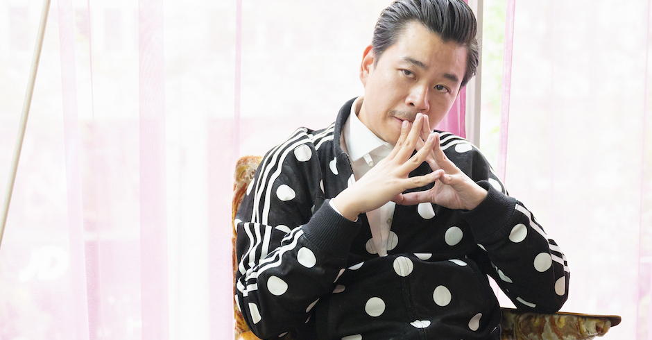 Der Szenegastronom mit gepunkteter Jacke und vor dem Gesicht aneinandergelegten Fingerspitzen