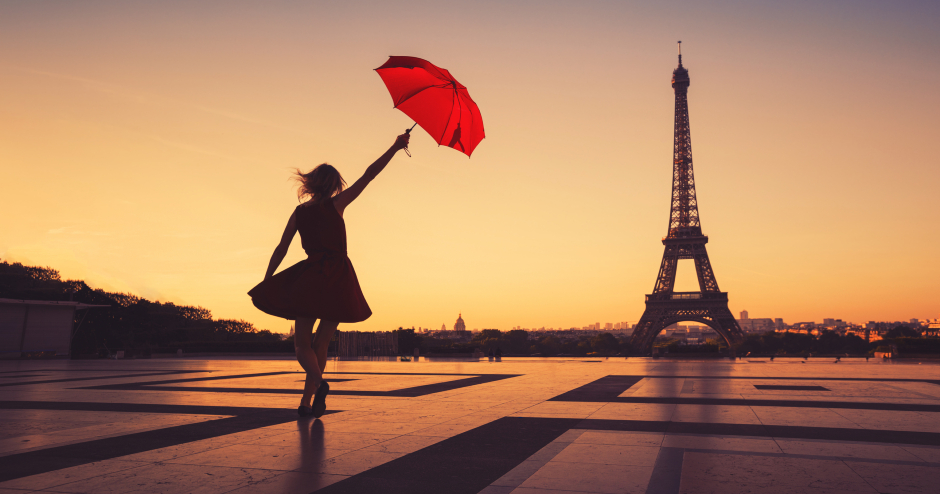 Frau im Sonnenuntergang mit rotem Sonnenschirm auf dem Weg zum Eiffelturm | Credit: iStock.com/anyaberkut