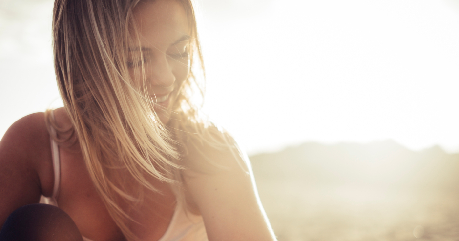 Glückliche junge Frau im Sonnenuntergang | Credit: iStock.com/simonapilolla